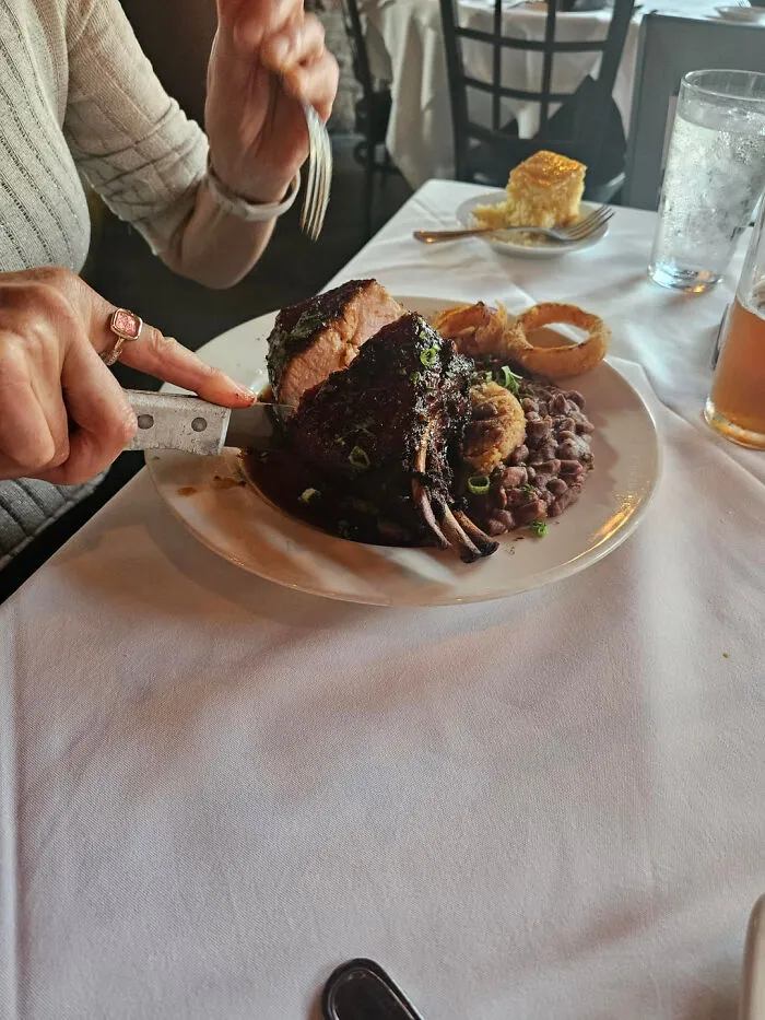A plate of meat, beans, and onion rings, showing bizarre food combinations at a restaurant