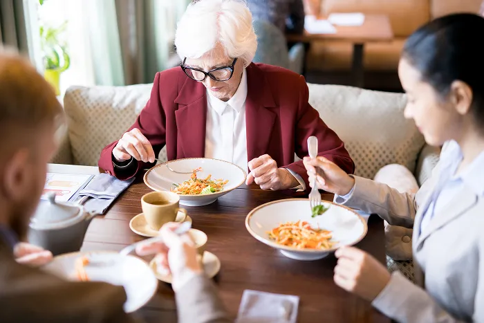 An elderly woman and friends dining in a restaurant, a cheap dining experience