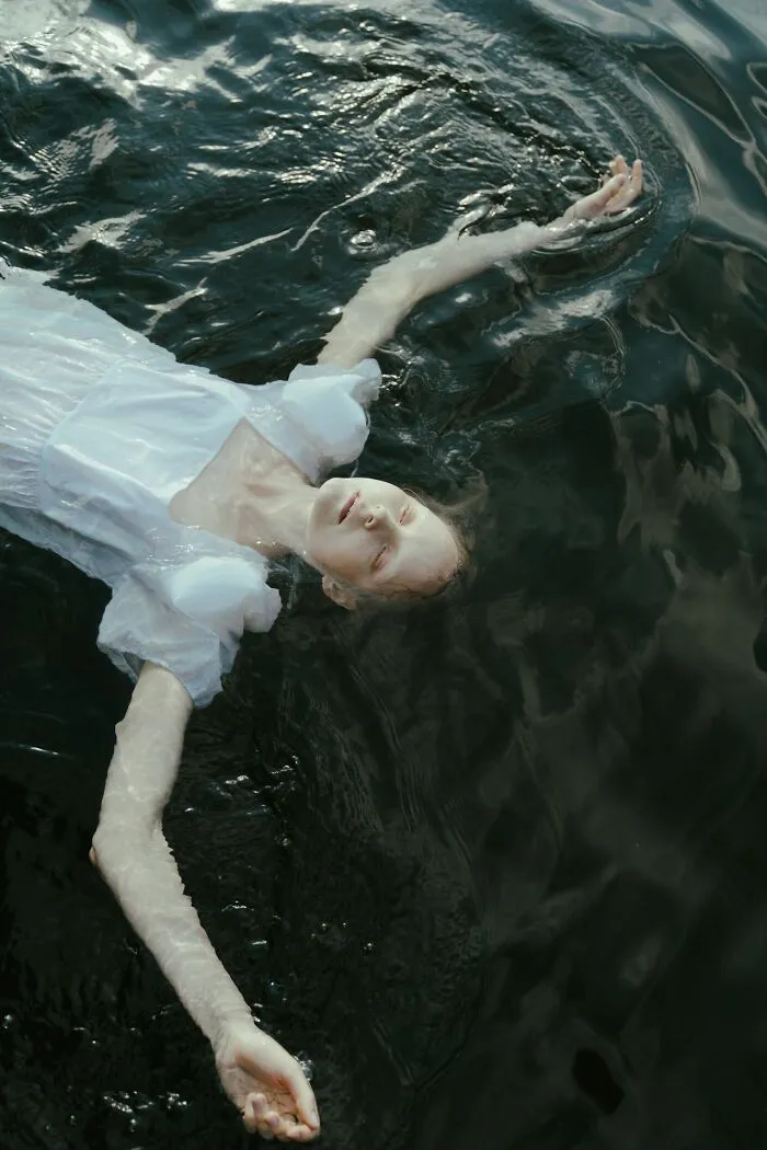 A woman floating on her back in dark water, highlighting useful facts for an emergency.