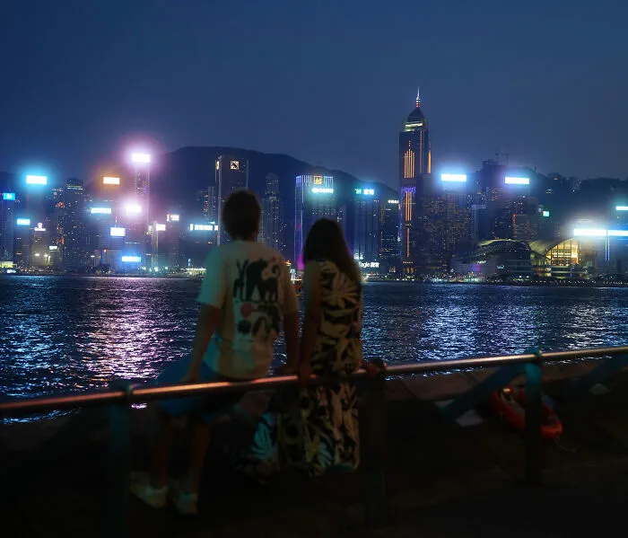 Couple enjoying nighttime cityscape by the water on vacation