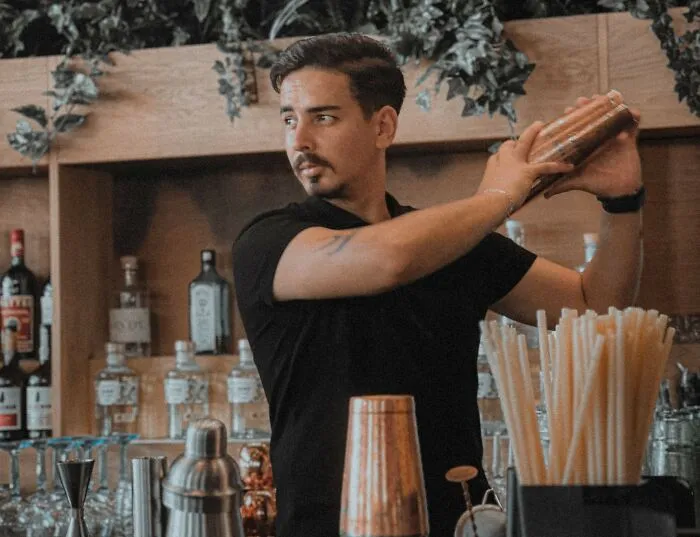 A bartender shaking a drink, reflecting how rich people might interact with service staff