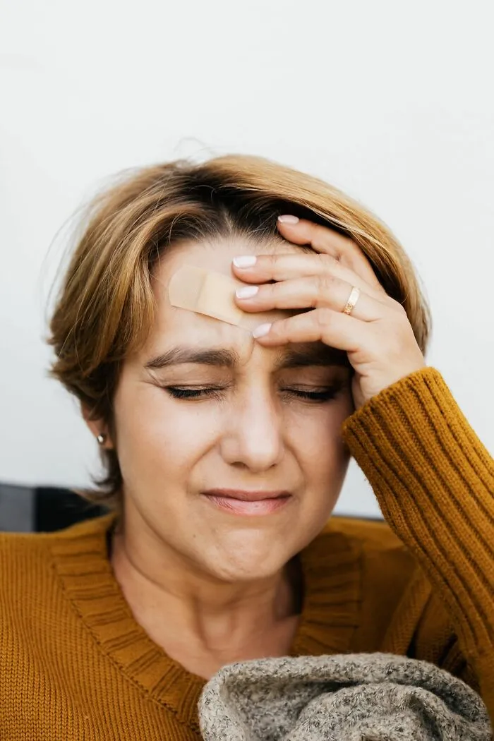 Woman with an adhesive bandage on her forehead, showing useful facts for a minor head injury.