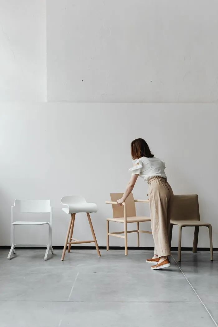 A woman arranging chairs in an empty room, highlighting useful facts for indoor safety.