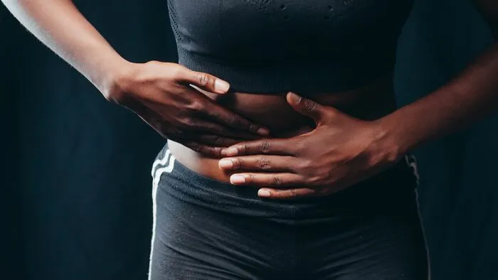 A person holding their stomach in pain, demonstrating useful facts about emergency stomach issues.