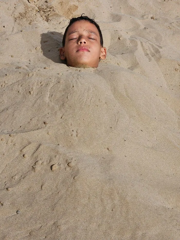 A boy buried in the sand up to his neck, useful facts in an emergency