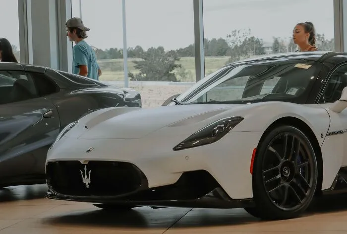 A white Maserati luxury sports car on display in a modern showroom