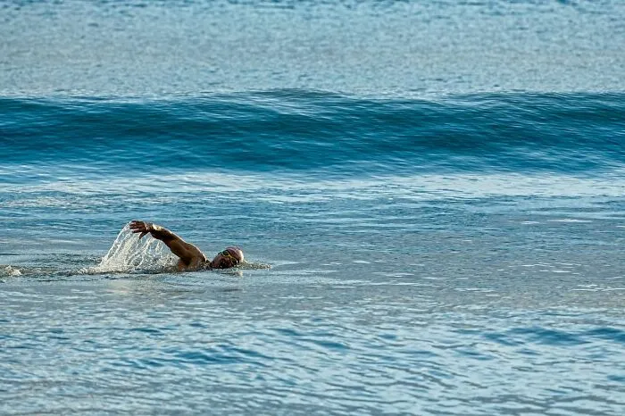 Man swimming in rough ocean waves, highlighting facts that could make a huge difference in an emergency