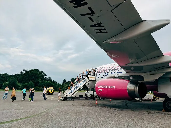 Passengers boarding Wizz Air plane at international airport during vacation