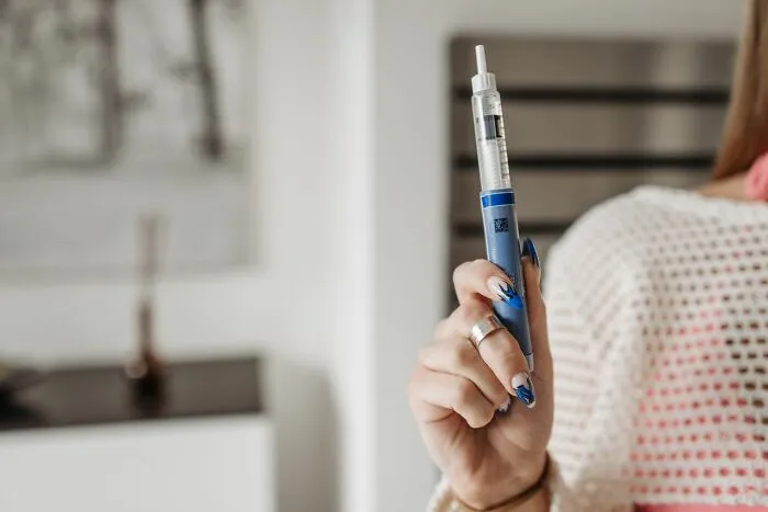 A woman holding an insulin injection pen, which can make a huge difference in an emergency medical situation.