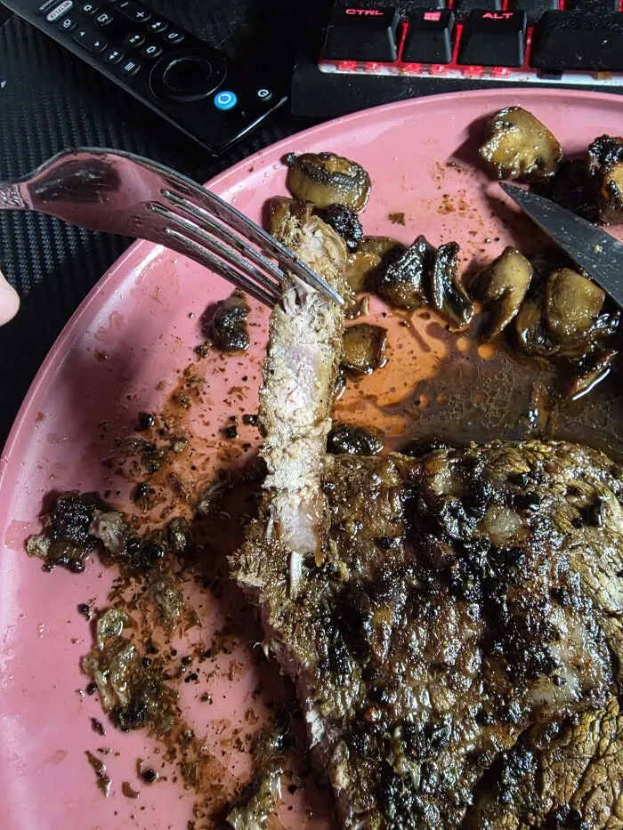 A slice of cooked steak held by a fork over a plate, depicting unique food combinations.
