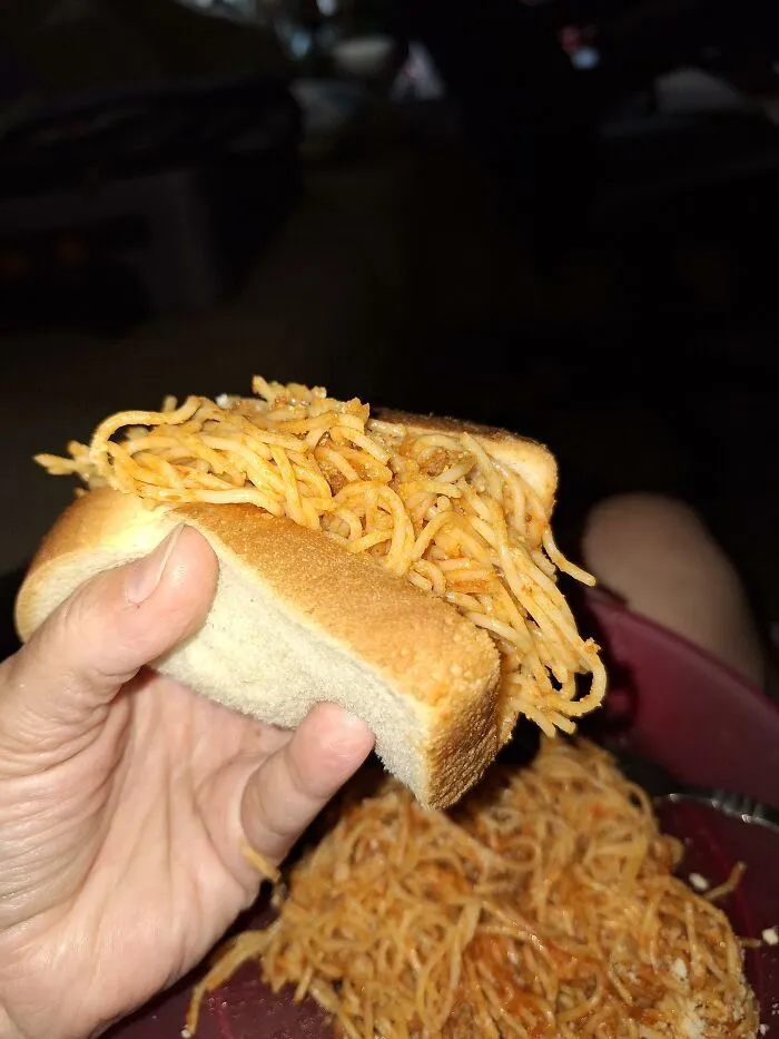 Odd food combinations featuring a spaghetti sandwich held in hand