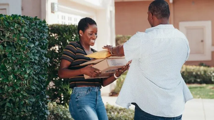 A happy couple receives packages at their doorstep, a scenario used for relationship revenge.