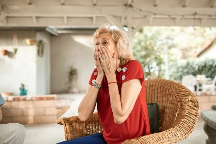 A shocked woman covers her mouth in surprise, reacting to shocking relationship revenge stories.