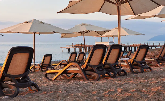 Empty lounge chairs with umbrellas on beach at vacation seaside