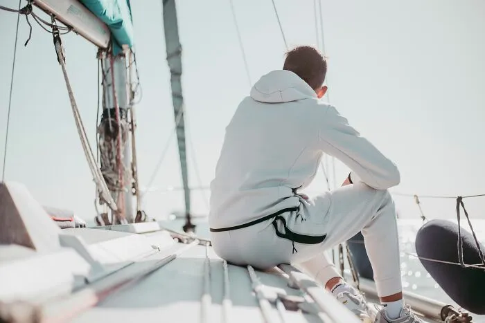 Man sitting on sailboat deck reflecting accidental secrets discovery