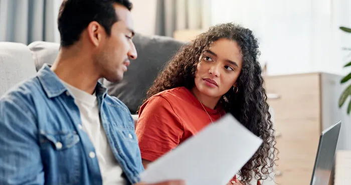 Woman listening attentively to man discussing clever insults indoors