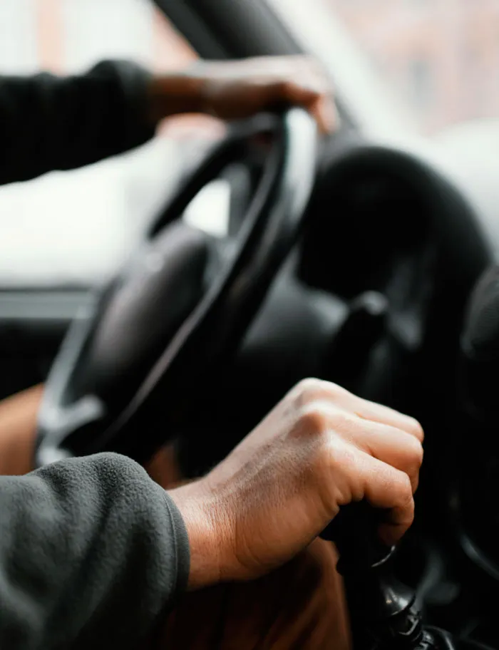 Hands on a steering wheel and gear shift representing life changes in divorce stories.