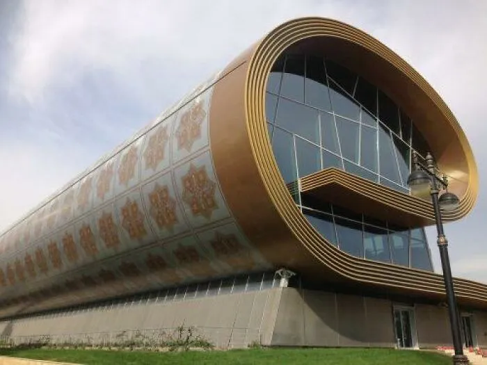 Modern building with a golden curved exterior and patterned decorative designs