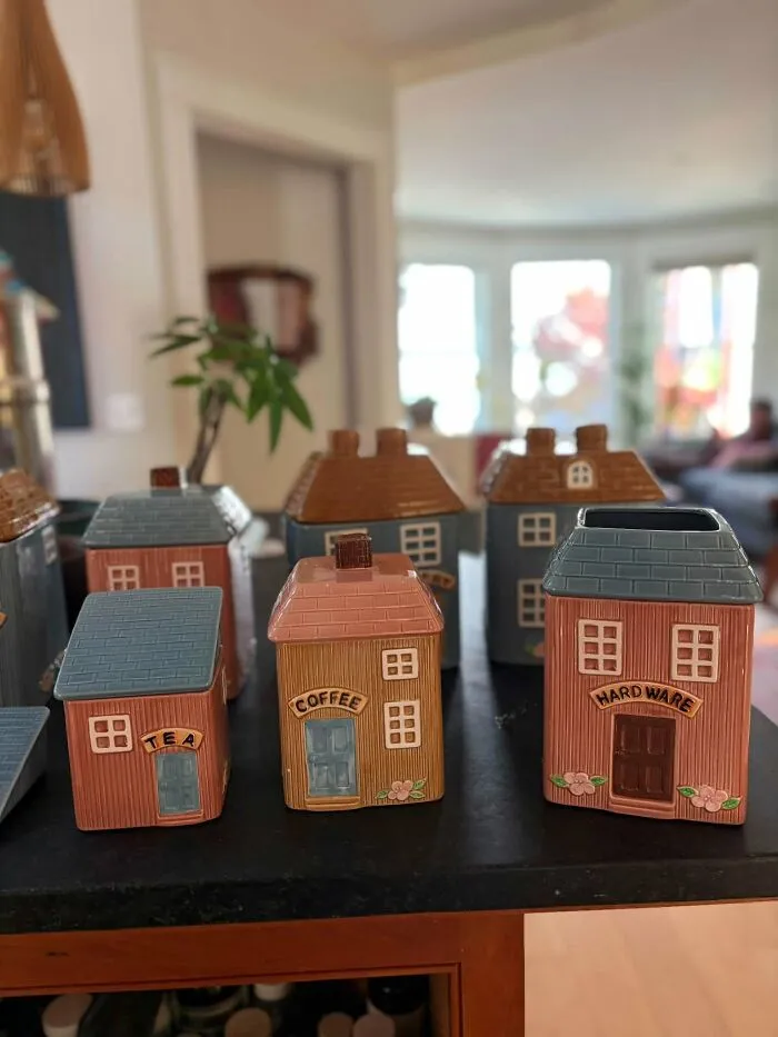 Village-themed ceramic kitchen canisters labeled tea coffee and hardware