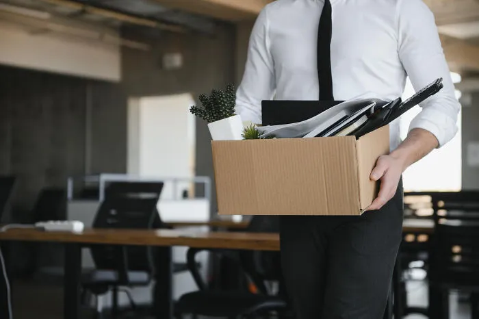 Man carrying a box of personal items leaving office