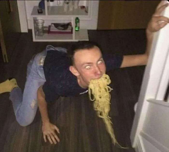 Cursed image of man on floor eating spaghetti from fridge