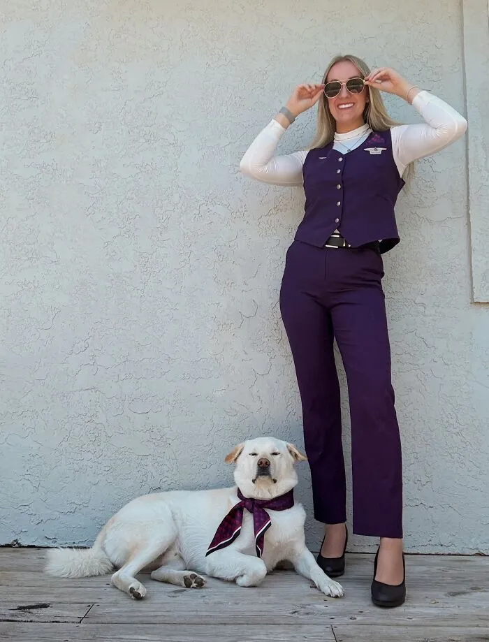 A woman and her dog wearing matching flight attendant uniforms showing how pets look like their owners.