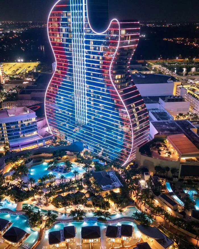 Guitar-shaped hotel illuminated with neon lights at night