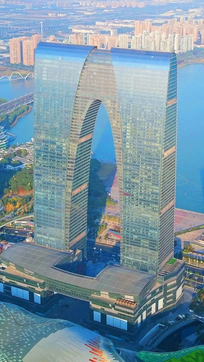 Tall strange building with an arch-shaped central design in city