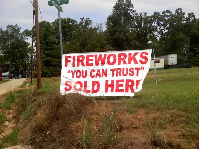 Fireworks sign misusing quotation marks around the phrase YOU CAN TRUST outdoors.