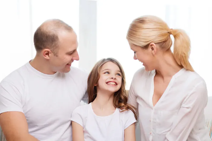 Happy young family sitting together, illustrating potential patients in a medical context.