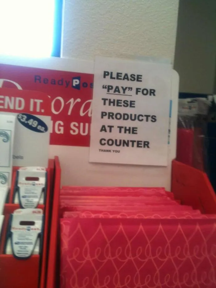In-store sign reading PLEASE PAY FOR THESE PRODUCTS, an example where people misused quotation marks.