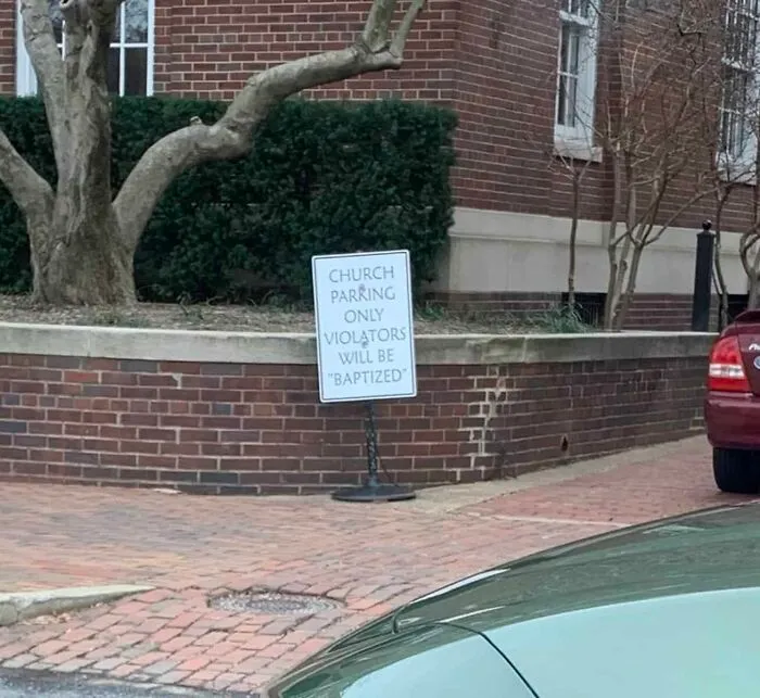 A sign misusing quotation marks outside a church reading Church Parking Only Violators Will Be Baptized.