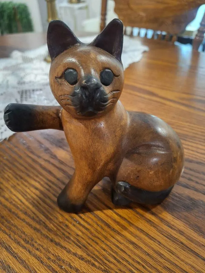 Hand-carved wooden cat figurine found at thrift store on wooden surface