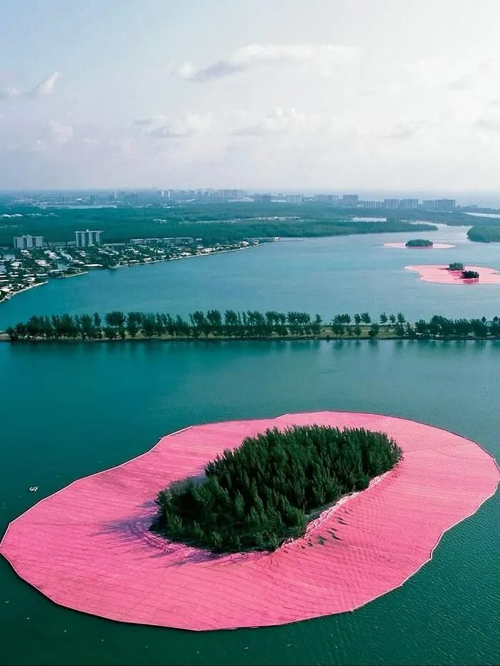 Aerial view of small islands surrounded by bright pink borders, making for entertaining pics in the water