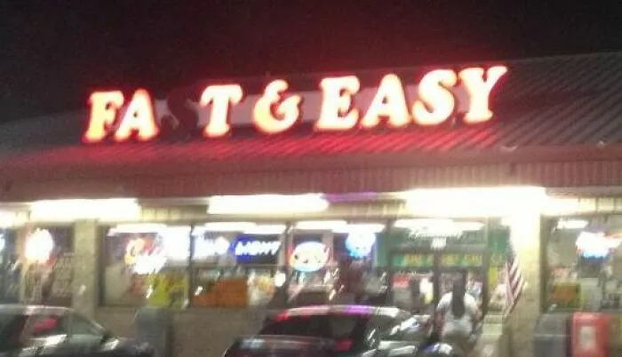 A glowing red storefront sign reading Fast and Easy in an advertising fails example