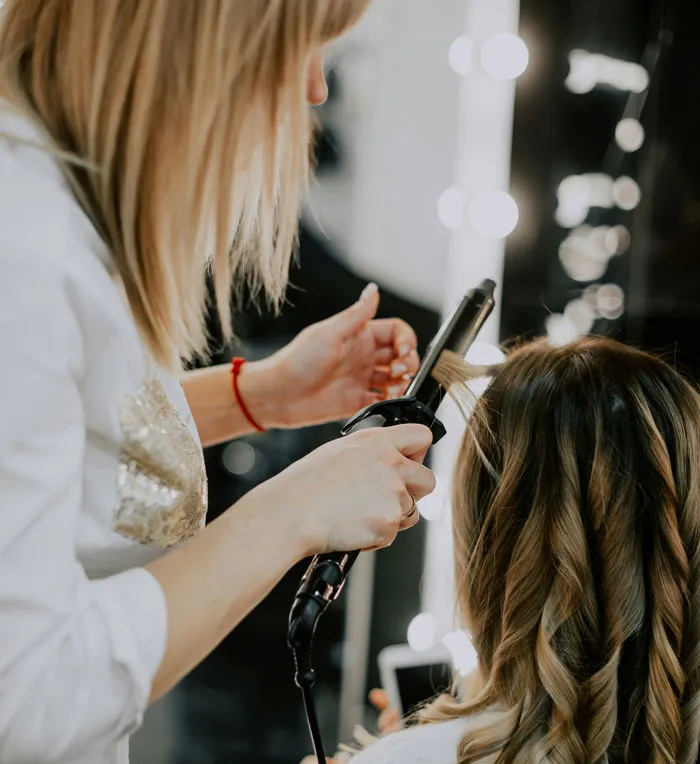 Hair stylist curling client's hair linked to bridezilla stories involving beauty preparations.