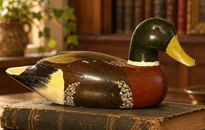 Vintage wooden duck decoy on old book thrift store collectible decoration