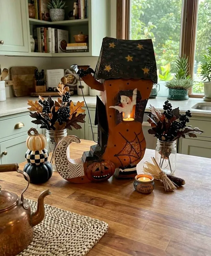 Halloween-themed boot candle holder with pumpkins and decorative foliage thrift store find