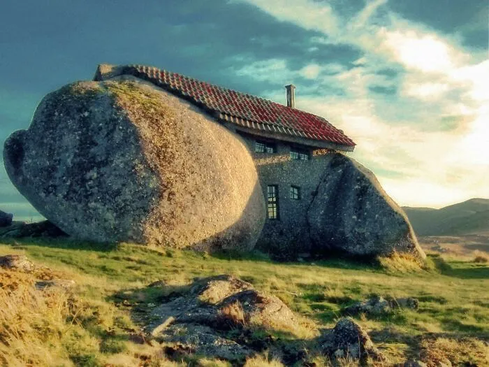 The Casa do Penedo in Portugal, built between massive boulders showcasing bizarre shapes.