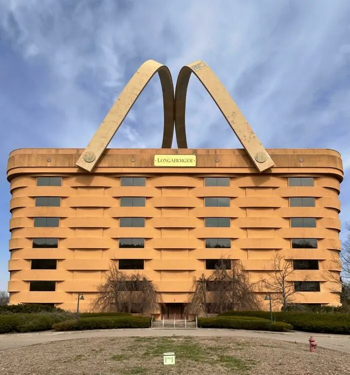 A unique office building with bizarre shapes designed to look like a giant brown picnic basket with large handles.