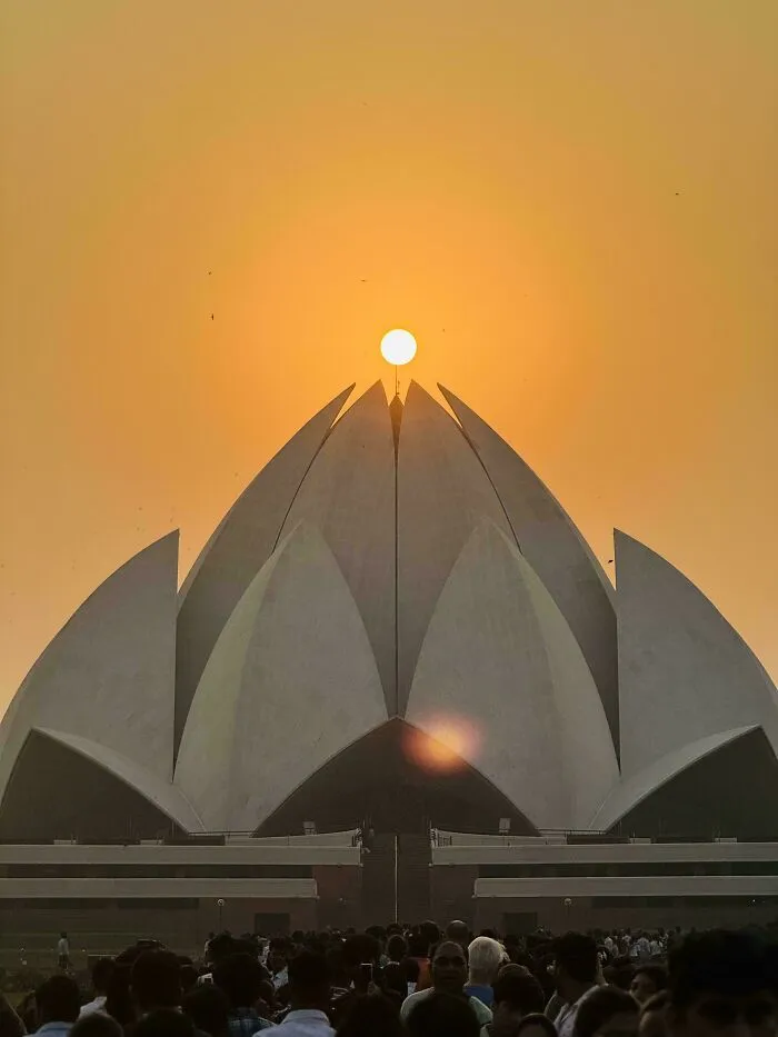The Lotus Temple showcasing bizarre shapes resembling flower petals against a golden sunset sky