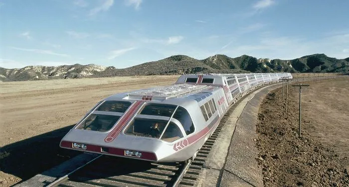 A futuristic streamlined silver land train traveling along tracks, exemplifying wonderful vehicles.