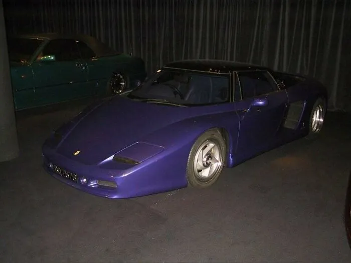 A sleek, dark purple low-slung concept supercar parked indoors, representing wonderful vehicles.
