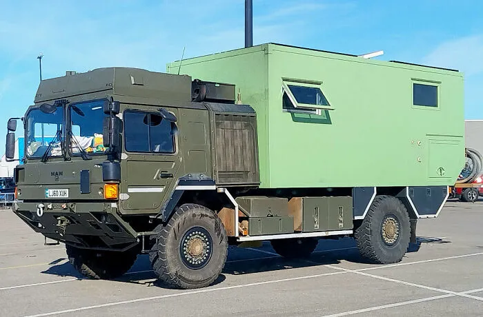 An off-road military camper truck with a green box shelter, one of many wonderful vehicles.