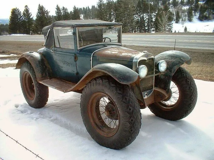 A vintage car modification featuring oversized off-road tires, highlighting wonderful vehicles.