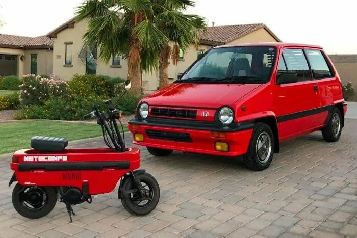 A compact red Honda City paired with its matching Motocompo scooter as unique wonderful vehicles.