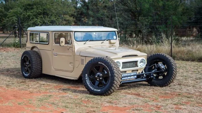 A customized tan hot rod SUV with exposed wide tires, exemplifying wonderful vehicles.