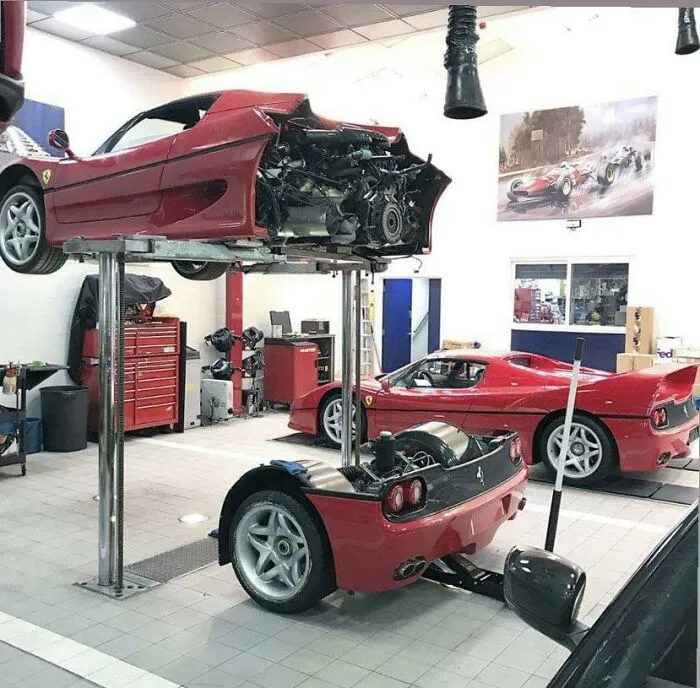 Disassembled red sports car inside an auto repair shop, showing unusual and wonderful vehicles being serviced.