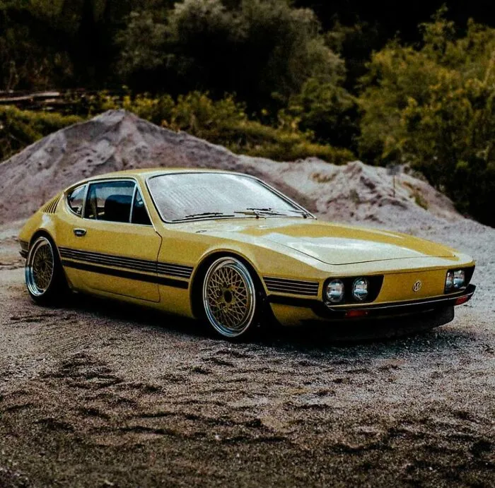 A sleek yellow vintage sports car parked outdoors, representing wonderful vehicles with unique retro designs.