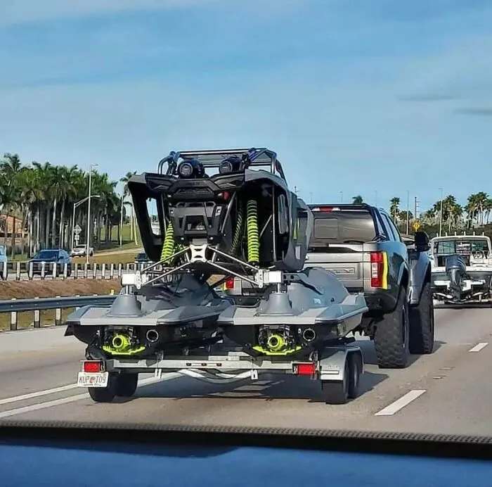 Rear view of a custom off-road vehicle mounted on jet skis, representing weird and wonderful vehicles on a trailer.